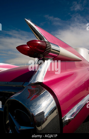 Les ailettes chromées iconique et feux arrière sur un pink Cadillac Coupe de Ville 1959 voiture classique avec ciel bleu Banque D'Images