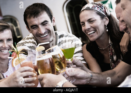 Trois hommes adultes et deux femmes adultes toasting leurs boissons Banque D'Images