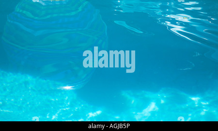 Reflet d'un ballon de plage floating in swimming pool Banque D'Images