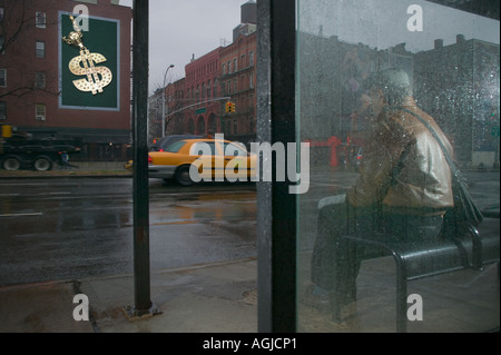 L'homme à la recherche d'abri bus à billboard Banque D'Images