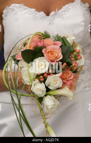Bouquet de fleurs roses rose et blanc tenue par bride à son service de mariage Banque D'Images