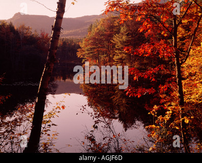 Red Eagle Pond dans le New Hampshire USA montrant les couleurs d'automne rouge et jaune compte dans les eaux du lac paisible Banque D'Images