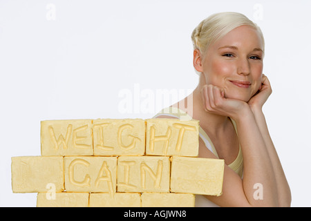 Jeune femme avec des blocs de beurre Banque D'Images