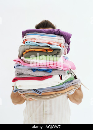 Homme avec pile of clothes Banque D'Images