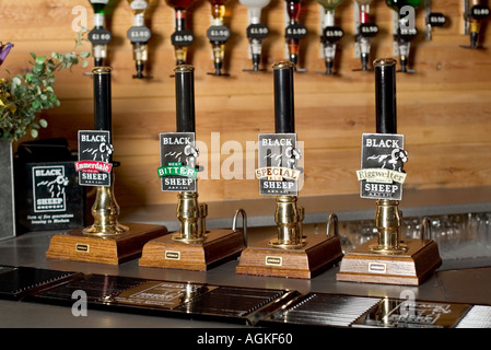 Pompes à bière sur un comptoir de bar pub avec optiques en arrière-plan à Black Sheep Brewery, Yorkshire, Angleterre, Royaume-Uni Banque D'Images