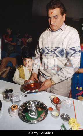 Père et fils tenant Diya sur Red Chopdis exécutant Chopda Puja pendant Diwali signifiant le début de la nouvelle année financière dans le calendrier hindou Banque D'Images