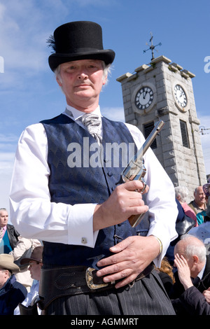 Événements écossais Creetown Festival de Musique Country cowboy posant avec un fusil à la place avec tour de l'horloge derrière Galloway Ecosse Banque D'Images