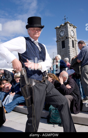 Événements écossais Creetown Festival de Musique Country cowboy posant avec un fusil à la place avec l'horloge derrière Galloway Scotland UK Banque D'Images