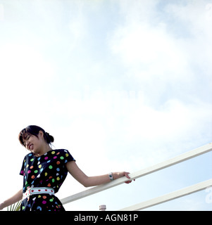 Jeune femme portant Polka Dotted Dress contre le ciel Banque D'Images