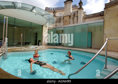 Trois jeunes femmes se baigner dans les sources chaudes des bains romains de Bath, Somerset. Banque D'Images