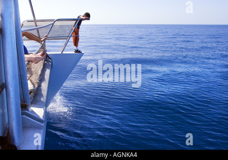 Catamaran à voile à la mer le garçon de 8 ans huit suspendues sur la rambarde regardant le rail reling DANGER eaux dangereux Banque D'Images