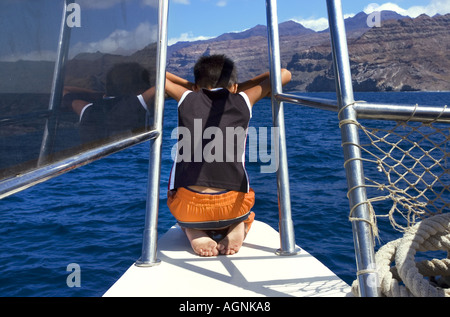 Catamaran à voile à la mer le garçon de 8 ans huit suspendues sur la rambarde regardant le rail reling waters Banque D'Images