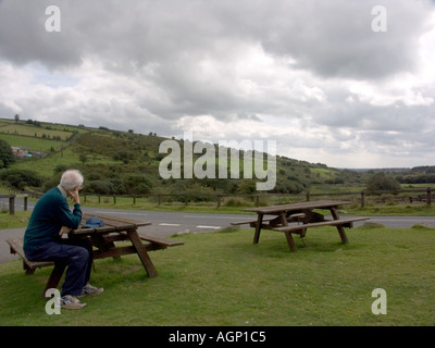 Vieux monsieur assis à une table, picknic Dartmoor National Park, Devon, Angleterre, Royaume-Uni, Banque D'Images