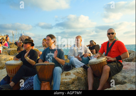 Israël Tel aviv beach batteurs de tambour sur les rochers Jaffa peut être vu dans l'arrière-plan Banque D'Images