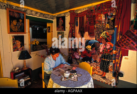 Guatemala Panajachel young woman reading magazine in restaurant Banque D'Images