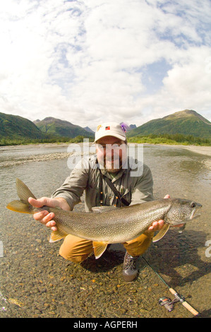 Au sud-ouest de l'Alaska Smiling Fisherman holding grand lac de la truite pêchée dans Nuyakuk Wood-Tikchik Parc Lac St. Banque D'Images