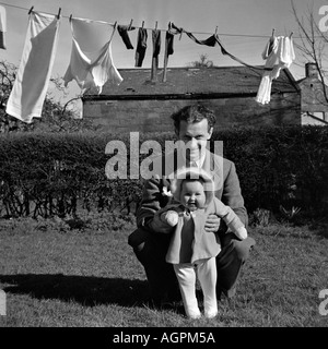 OLD VINTAGE SNAPSHOT PHOTO DE FAMILLE PÈRE jouant avec sa petite fille À JARDIN DE LA MAISON AVEC LAVE-LINE EN ARRIÈRE-PLAN : Banque D'Images