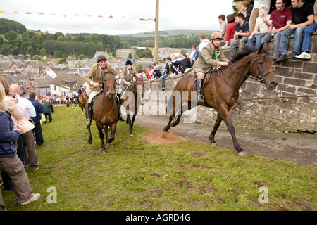 Des événements traditionnels écossais commun de l'équitation équitation Langholm jusqu'Kirk Wynd avec la foule acclamer sur Scotland UK Banque D'Images