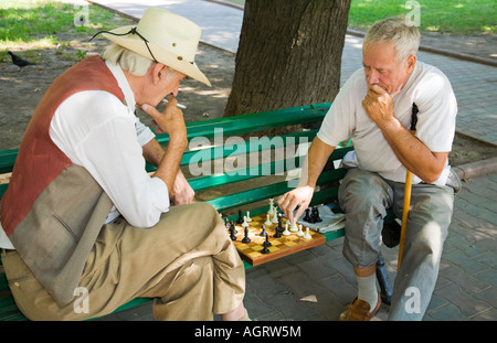 Deux hommes âgés jouant aux échecs sur un banc de parc à Odessa / Ukraine Banque D'Images