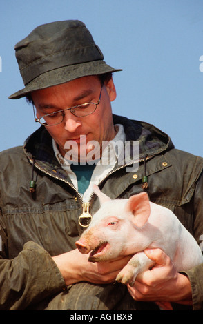 Agriculteur avec porcinet Banque D'Images