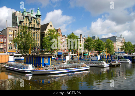 Des bateaux sur le canal Tour Damrak à Amsterdam Pays-Bas Banque D'Images