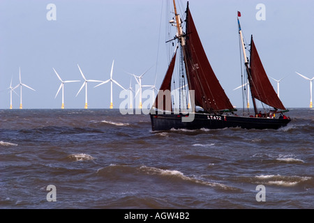 Vieux bateau de pêche voiles passé gt yarmouth wind farm Banque D'Images