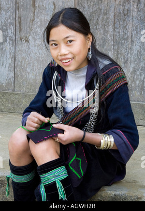 Jeune fille Hmong de vêtements traditionnels à coudre des vêtements tribus des collines près de Sapa au Vietnam. Banque D'Images