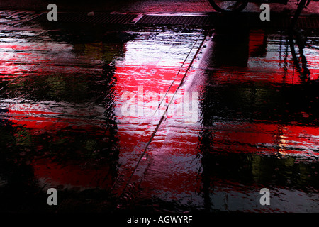 En raison de l'éclairage au néon de la chaussée mouillée pendant une tempête à Times Square, New York. USA Banque D'Images