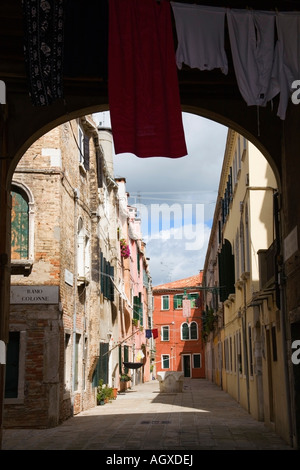 Silhouette d'archway avec lave-linge en train de sécher dehors menant dans une rue de Venise, Italie Banque D'Images