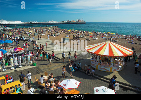 Estran Brighton sur une journée d'été avec manèges forains en premier plan et la jetée de Brighton dans l'arrière-plan. Banque D'Images
