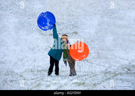 Asian Woman and Caucasian girl voisin jouer dans la neige Banque D'Images