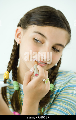 Girl putting sur make-up, portrait Banque D'Images