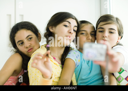 Young female friends avec make-up à la recherche de soi-même dans la main mirror Banque D'Images