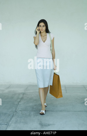 Woman carrying shopping bags, using cell phone, portrait Banque D'Images