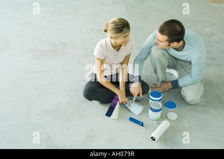 Couple sitting on floor looking at color swatches Banque D'Images