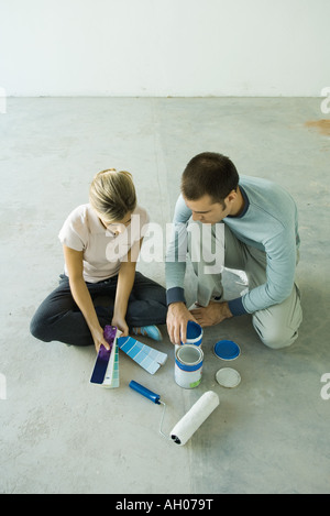 Couple sitting on floor looking at color swatches Banque D'Images