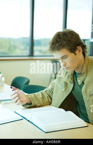 Young man studying in university library Banque D'Images