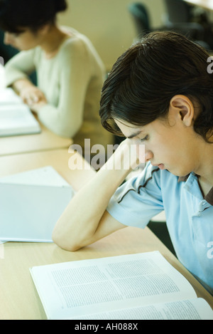 Young man studying in university library Banque D'Images