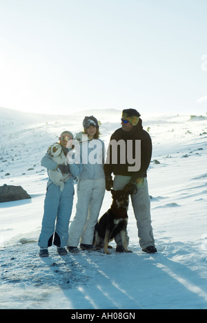 L'homme et deux filles debout dans la neige avec deux chiens, portrait Banque D'Images