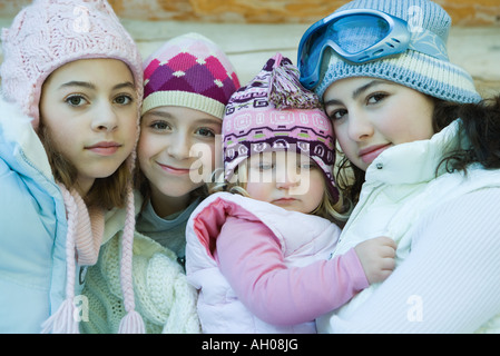 Trois ados ou filles préadolescentes avec tout-petit, qui portaient tous des manteaux d'hiver et de chapeaux, portrait Banque D'Images