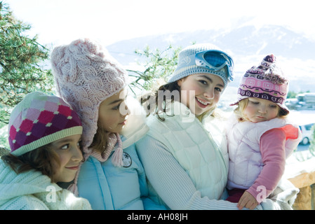 Trois ados ou filles préadolescentes avec tout-petit dans les montagnes, qui portaient tous des manteaux d'hiver et de chapeaux, portrait Banque D'Images