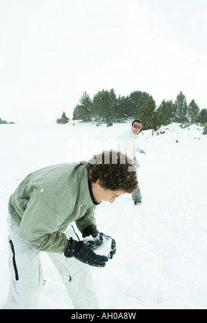 Young Friends having snowball fight in snow Banque D'Images