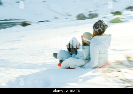 Jeunes amis de la luge en bas de la colline, blurred motion Banque D'Images