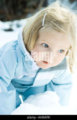 Bébé fille penché au-dessus de la neige, à l'écart Banque D'Images