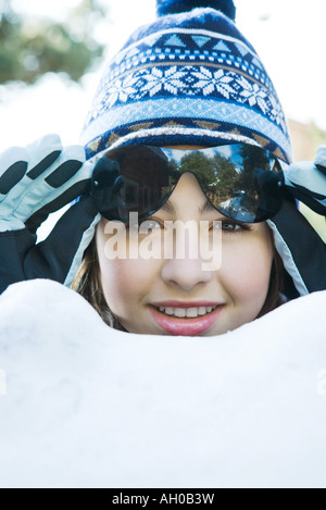 Teenage girl in snow, porter des vêtements d'hiver, lunettes de levage, portrait Banque D'Images