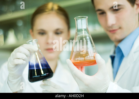 Les jeunes hommes et les femmes, les travailleurs de laboratoire verrerie de laboratoire holding Banque D'Images