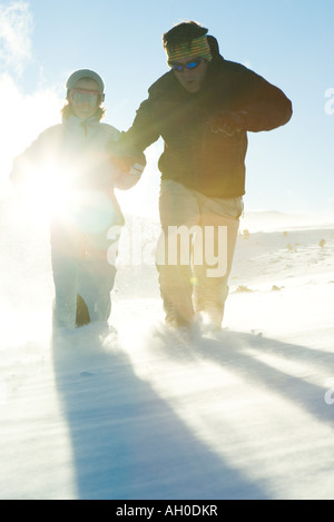 Père et fille s'exécutant dans la neige, vêtu de vêtements d'hiver, pleine longueur Banque D'Images