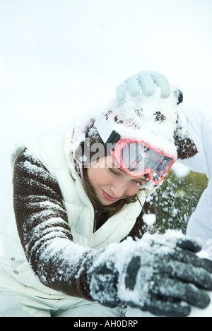 Teenage girl in snowball fight, penché au-dessus de Banque D'Images