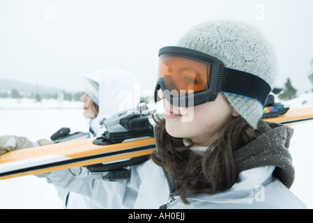 Deux jeunes skieurs portant sur l'épaule du ski, à l'écart, close-up Banque D'Images