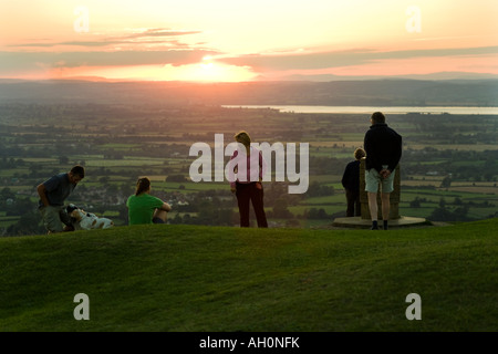 Une famille en regardant le coucher du soleil à partir de la vue sur la colline de Cotswold Frocester Coaley pique-nique pic adjacent, Gloucestershire Banque D'Images